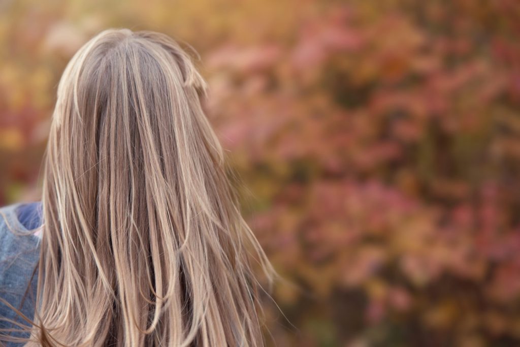 Woman with long hair seen from behind in warm natural light